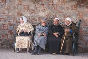 older people sit on a bench in Marakesh