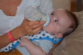 mother feeding baby with milk bottle