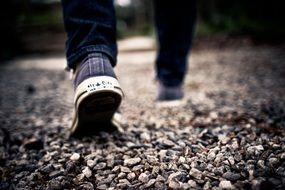 man walking on gravel