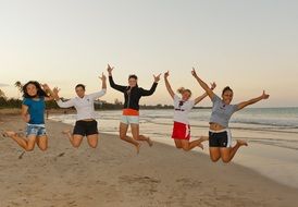 happy young girls jumping on beach, usa, puerto rico