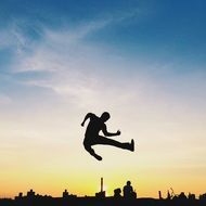 silhouette of a jumping man against the sunset