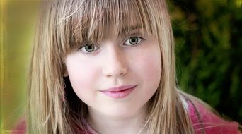 portrait of a cute blonde girl on a blurred background
