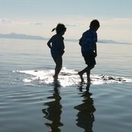 children walk on water at dusk