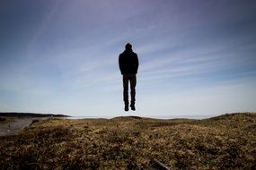 man jumping up the hill