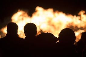 silhouettes of people against the backdrop of fire