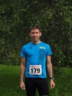 male runner with number 179 on shirt at greenery