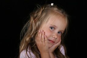 little girl holding her head