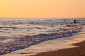 fisherman on the ocean at sunset