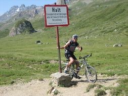 athlete on a mountain bike near the sign in the mountains of austria