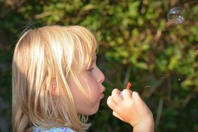 girl is blowing soap bubbles