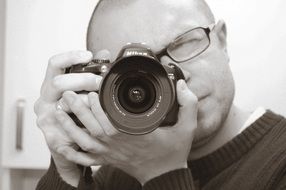 Black and white image of a photographer with a camera in his hands