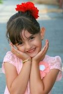 child with a red flower in her hair