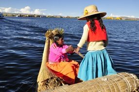 two child girls in traditional boat on titicaca lake