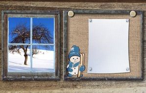 bulletin board and a picture with winter nature on the wall