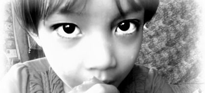 black and white photo of a child with big eyes