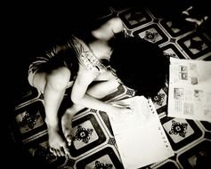 young girl writes on the floor black and white photo