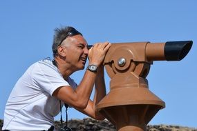 man is looking with binoculars