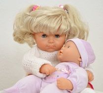 cute doll with white hair holds baby doll