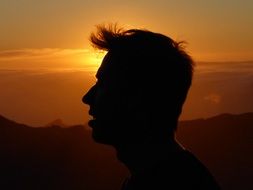 portrait of silhouette of man head at sunset sky