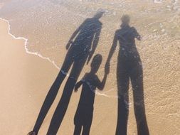 family shadows on beach