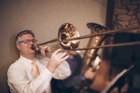 man playing trombone near the wall