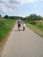 dad teaches son to ride a bike on a sunny day