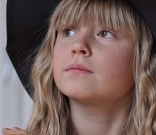 blonde pensive girl in a black hat