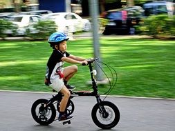 boy on a black bike in the park