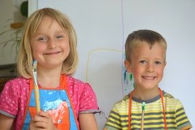smiling girl boy painting with brushes