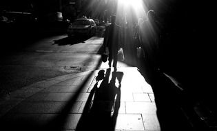 black-white image of people on a city street in the dark