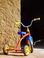 colorful tricycle at wall