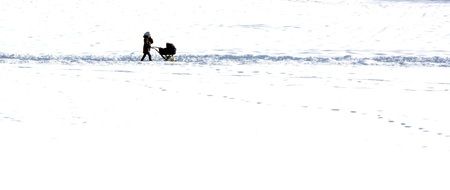 a man with a stroller is on a snowy field