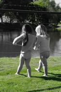 Little girls walking on green grass