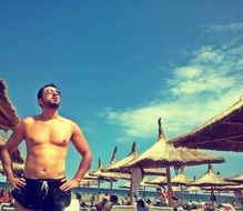 man with the glasses sunbathing on the beach