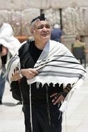 a man in a tallit near the western wall in Jerusalem