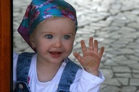 little girl with blue eyes looks out the window