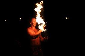 man dancing with fire in hawaii