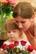 mother and daughter smell flowers