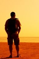 lonely man on the ocean beach in the evening