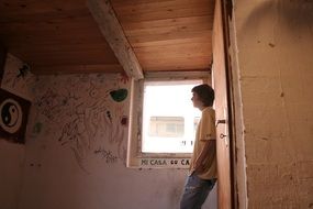 teen boy stands by a painted wall