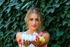 young girl holds artificial flowers in stretched hands