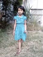 little girl in a blue dress outdoors