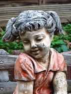 girl stone statue in a garden