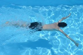 man swims in the pool water