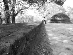 black and white photo of a man sitting on a parapet Â  in sri lanka