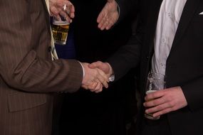 shaking hands with a beer in the other hand