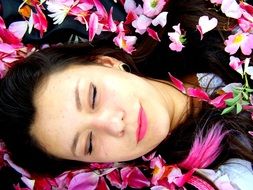 girl is lying with pink petals