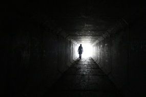 silhouette in a long dark tunnel