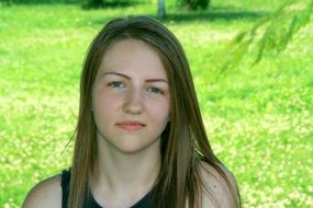 portrait of a blonde girl on a background of green nature