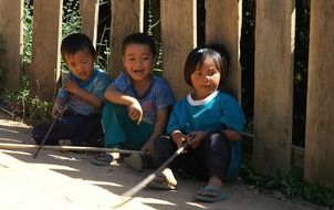 asian children at fence on road, thailand